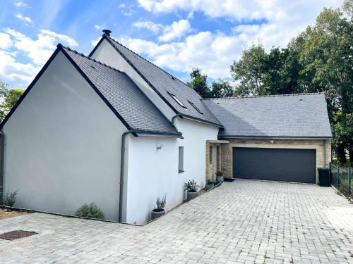 a white garage with a black roof at Holiday Home L'allée Couverte by Interhome in La Trinité-sur-Mer