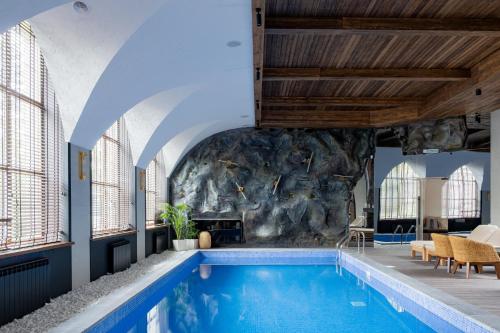 an indoor swimming pool with a rock wall at Дом у озера in Shchūchīnsk