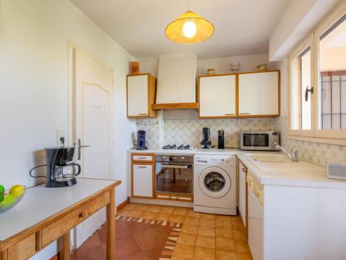 a kitchen with a washer and dryer at Apartment Les Mimosas-1 by Interhome in Saint-Aygulf