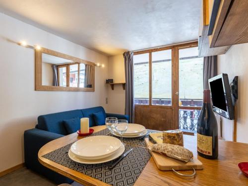 un salon avec une table et un canapé bleu dans l'établissement Studio Rond Point des Pistes - Val Claret-13 by Interhome, à Tignes