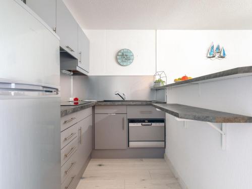 une cuisine blanche avec des placards blancs et un comptoir dans l'établissement Apartment La Chênaie-4 by Interhome, à Saint-Aygulf