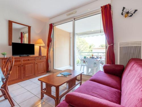 een woonkamer met een bank en een tafel bij Apartment Les Calanques du Parc-3 by Interhome in Saint-Aygulf
