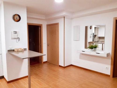 馬爾皮卡的住宿－Cómodo apartamento en la costa Gallega，一间拥有白色墙壁和木地板的客房