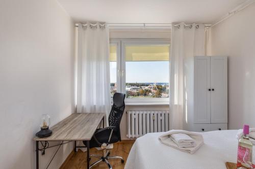 a bedroom with a bed and a desk and a window at Salt Island Apartment Sea and Harbor View by Renters in Kołobrzeg