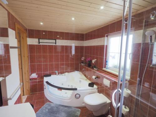 a bathroom with a tub and a toilet at Holiday Home Sissi by Interhome in Großschönau