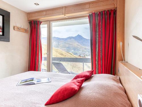 une chambre avec un lit avec des oreillers rouges et une fenêtre dans l'établissement Apartment Le Bec Rouge - Le Lac-9 by Interhome, à Tignes