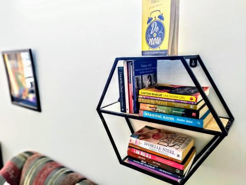 a book shelf filled with books on a wall at Entire Studio Apt/Suite near Mall/Metro/ExpoMart in Noida