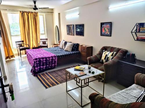 a living room with a bed and a coffee table at Entire Studio Apt/Suite near Mall/Metro/ExpoMart in Noida