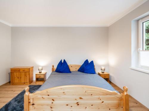 - une chambre avec un lit en bois et des oreillers bleus dans l'établissement Apartment Poyraz, à Bad Gastein