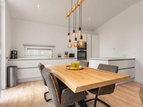 a kitchen and dining room with a wooden table and chairs at Holiday Home Ruisweg 80 by Interhome in Wemeldinge