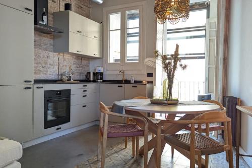 a kitchen with a table and chairs and a kitchen with white cabinets at CRASH'NSTAY - Casa Barna in Barcelona