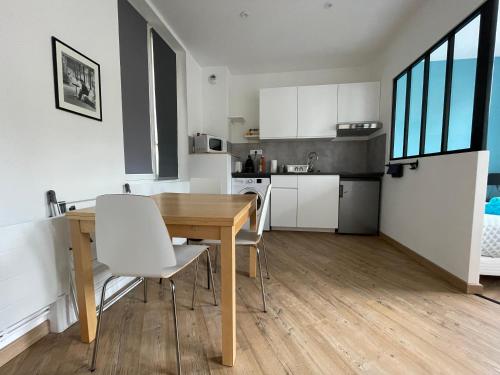 une cuisine et une salle à manger avec une table et des chaises en bois dans l'établissement L'avalasse - Petit appartement centre de Rouen - 121, à Rouen