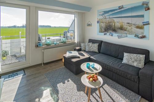 a living room with a couch and a table at Ferienwohnung Ausblick in Norddeich