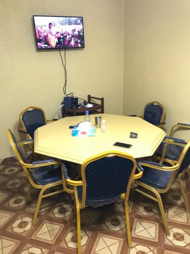 uma sala de conferências com uma mesa e cadeiras e uma televisão em Bel Appartement meublé à Bafoussam em Bafoussam