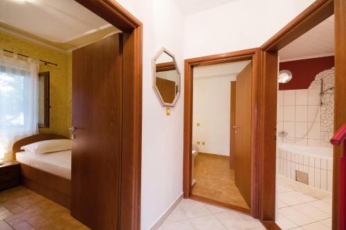 łazienka z łóżkiem i wanną w pokoju w obiekcie Apartman Mediterraneo w mieście Supetar