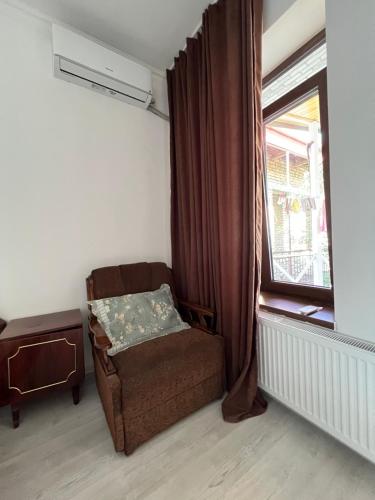 a living room with a chair and a window at Guest House Lali in Sighnaghi
