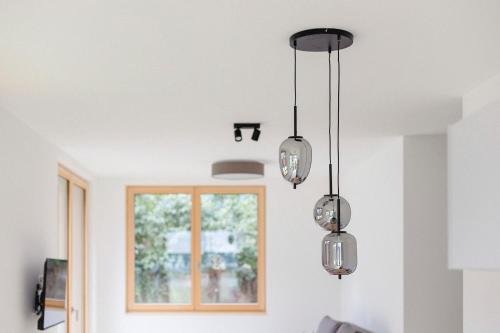 a kitchen with several glass lights hanging from the ceiling at am Greben Apartments drei - vier - fünf in Bezau