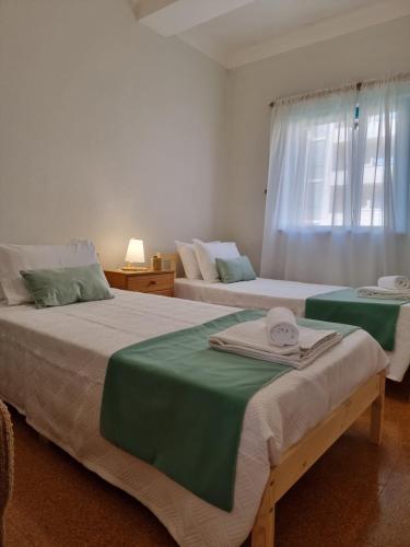 two beds in a room with a window at Blue Waves Quiaios Apartment in Praia de Quiaos