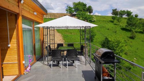 a patio with a table and chairs under an umbrella at Villa unforgettable in Sarajevo