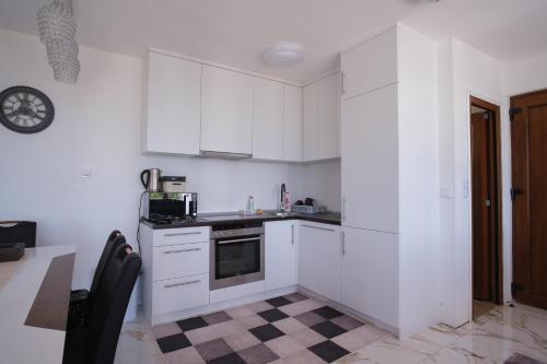 a kitchen with white cabinets and a stove top oven at Villa unforgettable in Sarajevo