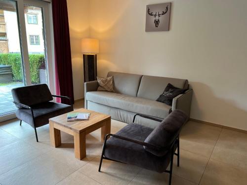 a living room with a couch and a chair at Apartment Ski & Golf Suites Zell am See by Interhome in Zell am See