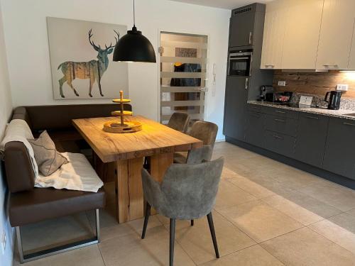 uma cozinha com uma mesa de madeira e uma sala de jantar em Apartment Ski & Golf Suites Zell am See by Interhome em Zell am See