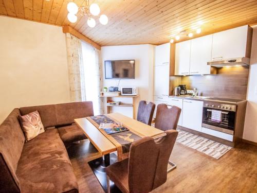 eine Küche und ein Esszimmer mit einem Tisch und einem Sofa in der Unterkunft Apartment Pircher by Interhome in See