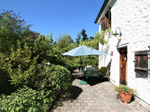 een patio met een parasol en een tafel en stoelen bij Holiday Home Vogelhütte by Interhome in Innsbruck