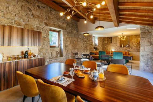 a dining room with a wooden table and chairs at ICH Inveja Country House in Paços de Ferreira