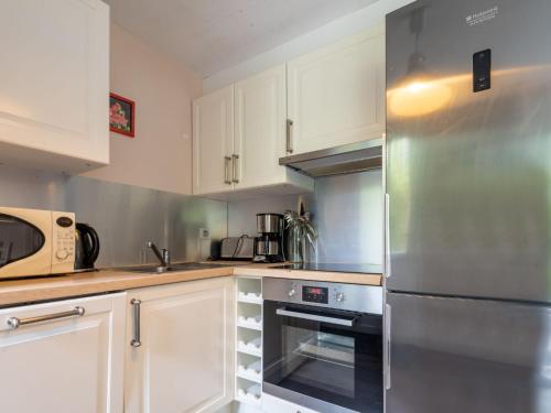 una cucina con armadi bianchi e frigorifero in acciaio inossidabile di Holiday Home La Glycine by Interhome a Beuvron-en-Auge