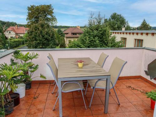 a wooden table and chairs on a balcony at Holiday Home Řevnice by Interhome in Řevnice
