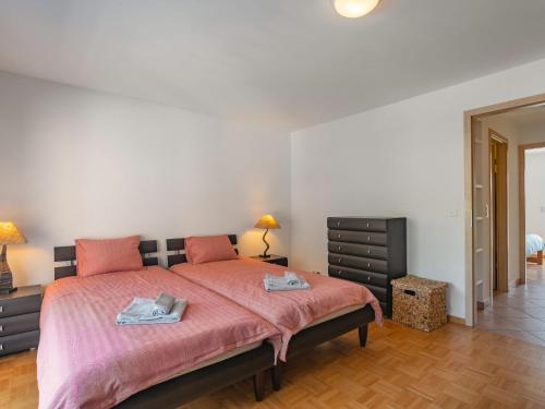 a bedroom with a bed with two towels on it at Apartment Tasman S16-R by Interhome in Bouveret