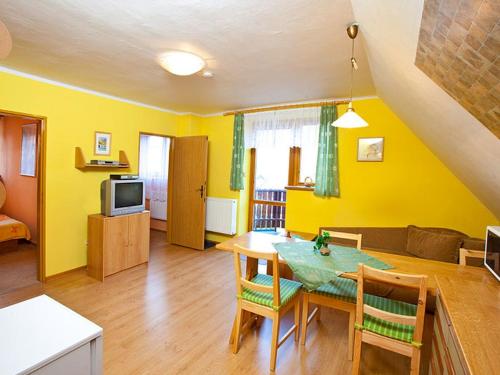 - un salon avec des murs jaunes, une table et des chaises dans l'établissement Apartment Rieger 3 by Interhome, à Harrachov