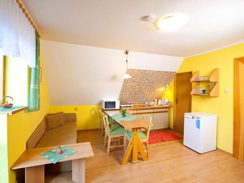 a kitchen with yellow walls and a table in a room at Apartment Rieger 3 by Interhome in Harrachov