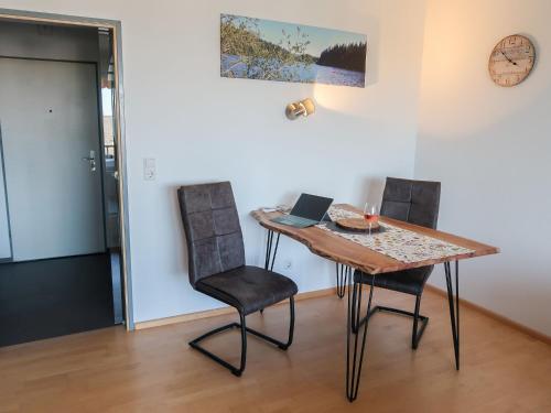 Apartment Alpensicht by Interhome في هوتشنشوند: طاولة غرفة طعام مع كراسي وجهاز كمبيوتر محمول عليها