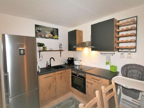 a kitchen with wooden cabinets and a stainless steel refrigerator at Apartment Chalet Astholz by Interhome in Strass