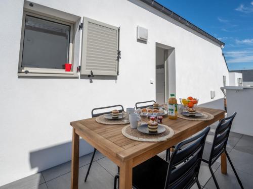 einen Holztisch und Stühle auf dem Balkon eines Hauses in der Unterkunft Apartment Le Clos Moguer-2 by Interhome in Quiberon