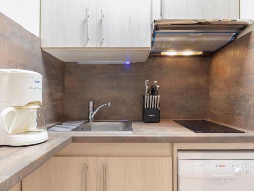 une cuisine avec un évier et un micro-ondes dans l'établissement Apartment Les Lauzes D25 by Interhome, aux Menuires
