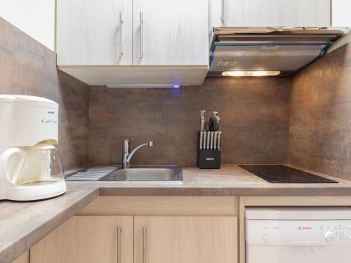 a kitchen with a sink and a microwave at Apartment Les Lauzes-7 by Interhome in Les Menuires