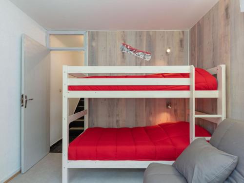 a bedroom with two bunk beds with red sheets at Apartment Les Lauzes-7 by Interhome in Les Menuires