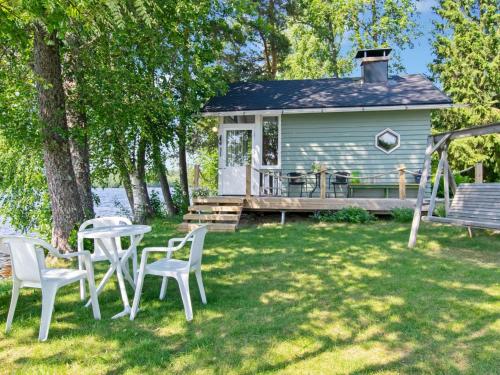 a house with a table and chairs in the yard at Holiday Home Villa kesäranta by Interhome in Muurame