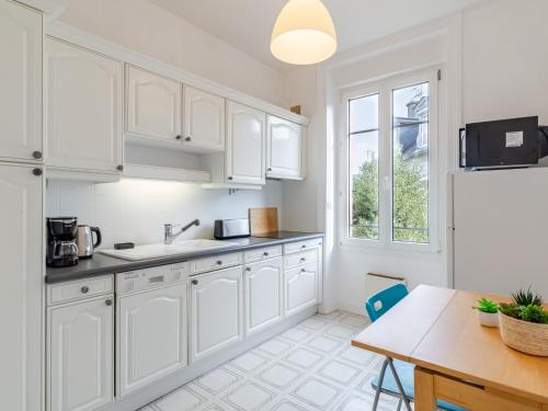 a kitchen with white cabinets and a table and a window at Apartment L'écluse-2 by Interhome in Dinard