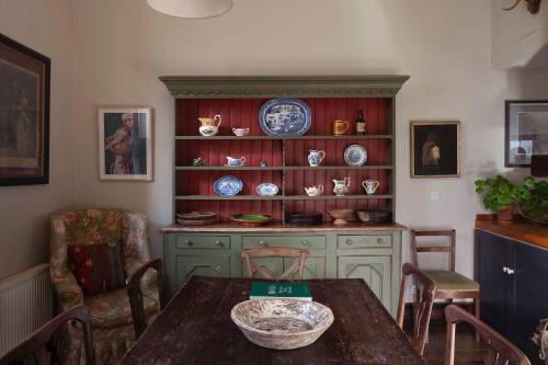 a dining room with a table and plates on a shelf at The Stable Yard House at Burtown House & Gardens in Athy