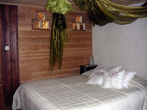a bedroom with a bed with white sheets and pillows at Le Verger Sous Les Vignes in Villeferry