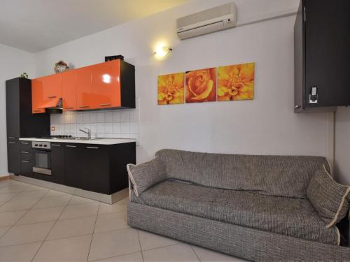 a living room with a couch and a kitchen at Apartment Rosapanna-2 by Interhome in Rosapineta