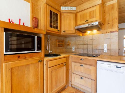 - une cuisine avec des placards en bois et un four micro-ondes dans l'établissement Studio Les Moutières B1 et B2 - Val Claret-25 by Interhome, à Tignes