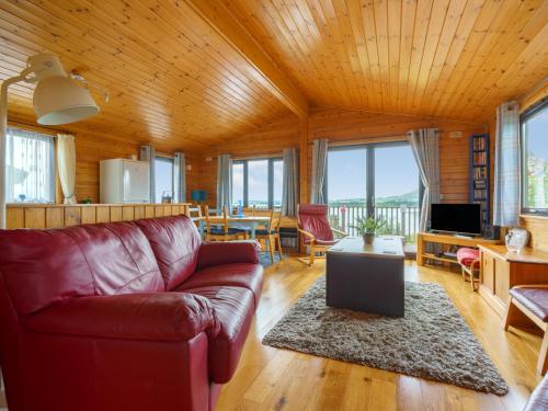 a living room with a red couch and a table at Chalet Lodge 9 by Interhome in Kinross