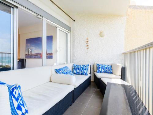 - un canapé sur un balcon avec des oreillers bleus et blancs dans l'établissement Apartment Kivu by Interhome, à Oropesa del Mar