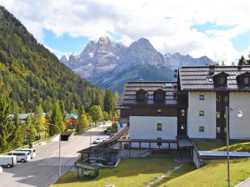 a building with a tennis court in front of a mountain at Studio Frassan Apartments-3 by Interhome in Madonna di Campiglio