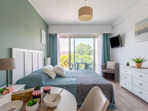 une chambre avec un lit et une table avec des chaises dans l'établissement Studio Le Tremblay by Interhome, à Cagnes-sur-Mer